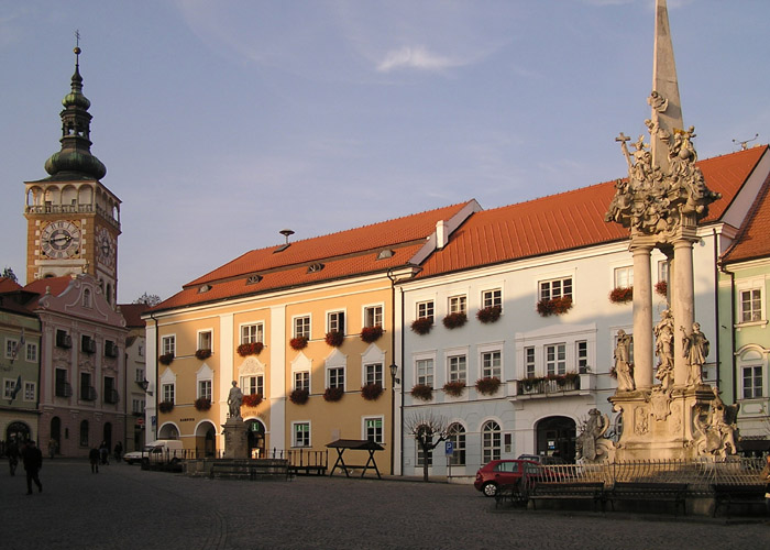 Náměstí se sloupem sv. Trojice (1723-24) a věž kostela sv. Václava (současná podoba přibližně z let 1636-40)